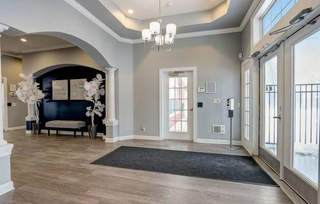 a large foyer with a black couch and a chandelier