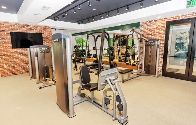 a spacious fitness room with cardio machines and weights