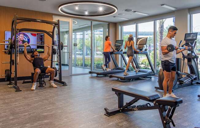 A man is working out on a machine in a gym with other people exercising in the background.at Icon One, Florida, 32114