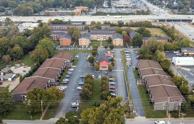 A parking lot in front of a building with a red roof.