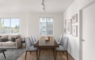 A dining room with a wooden table and grey chairs.