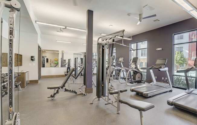 a gym with weights and other exercise equipment and windows