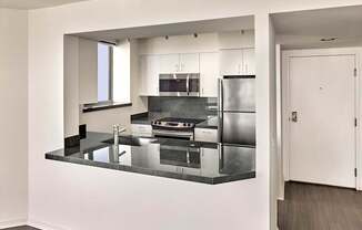 A modern kitchen with a refrigerator, sink, and stove.