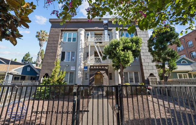 an apartment building with a fence and a gate in front of it