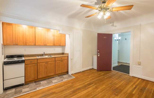 a kitchen and living room with wood floors and a ceiling fan