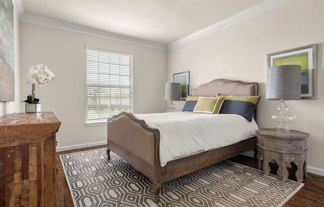 A bedroom with a bed, nightstand, and lamp.