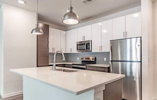 A modern kitchen with a large island and stainless steel appliances.