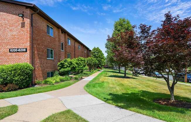 A building with the number 6200-6208 on it is surrounded by greenery and a paved walkway.