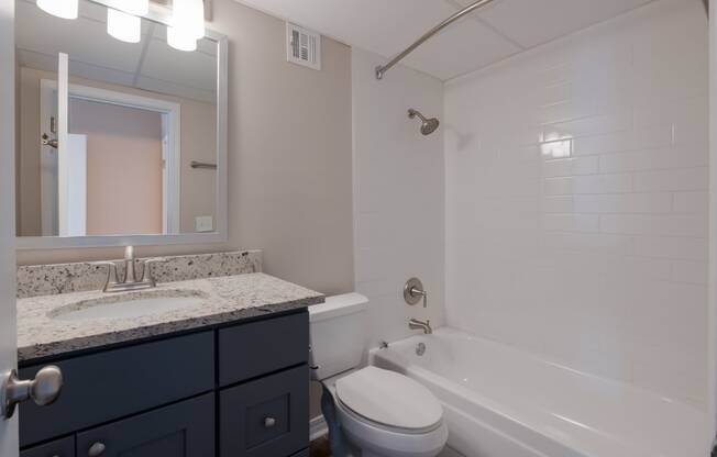 a bathroom with a white tub and sink and a toilet