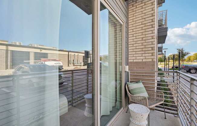 A balcony with a chair and a table.