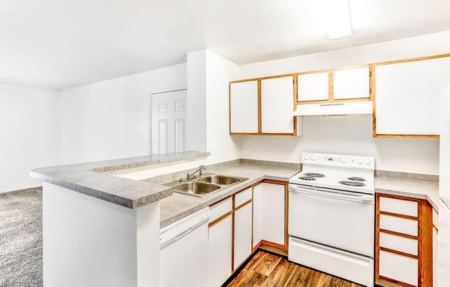 Kitchen with White Appliances, Grey Counters and White Cabinets with Wood Accents