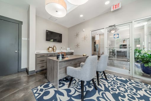 a living room with a desk and chairs