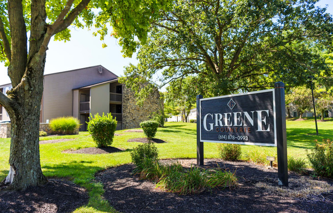 a sign that says greene apartments with a building in the background