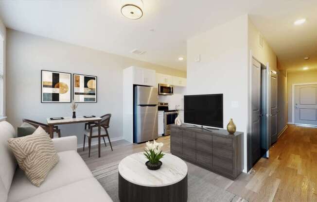 A modern living room with a white sofa, a grey coffee table, and a flat screen TV.
