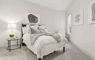 A bedroom with a bed, nightstand, and wall art pieces at Knox Heights Apartments in Dallas, TX