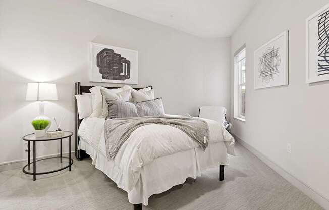 A bedroom with a bed, nightstand, and wall art pieces at Knox Heights Apartments in Dallas, TX