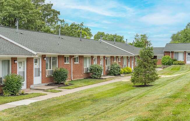 A row of houses with green lawns in front.