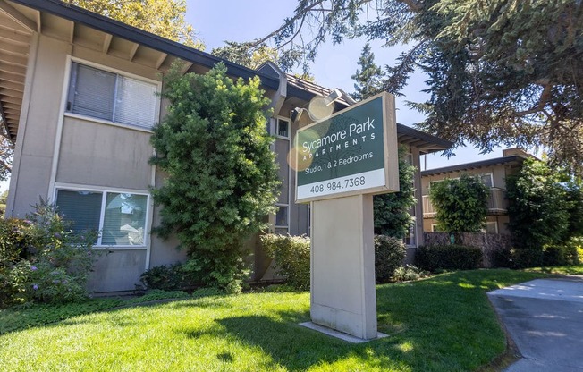 an apartment building with a sign in front of it