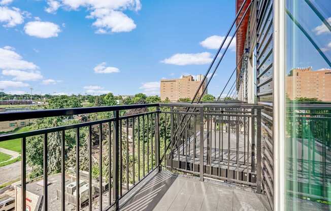 the balcony has a view of the city and the trees