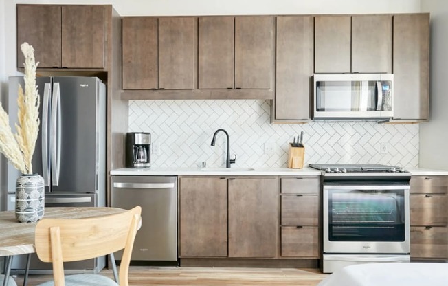 a kitchen with wooden cabinets and stainless steel appliances and a table