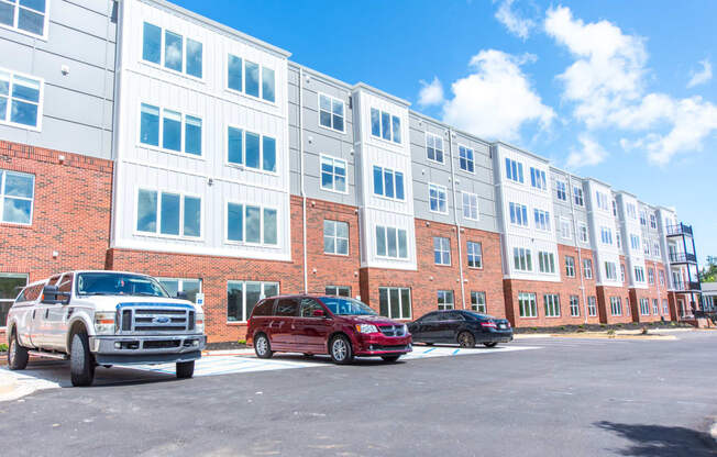 a large apartment building with cars parked in front of it