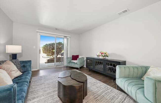 a living room with a blue couch and a sliding glass door