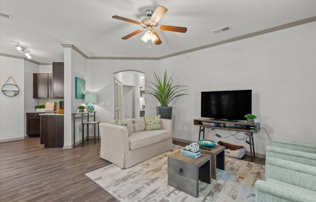 a living room with white walls and a ceiling fan