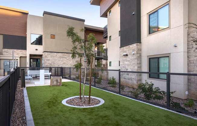 A modern house with a small tree in a circular garden.