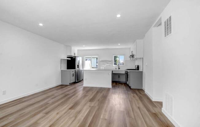 a living room with a kitchen and a hard wood floor