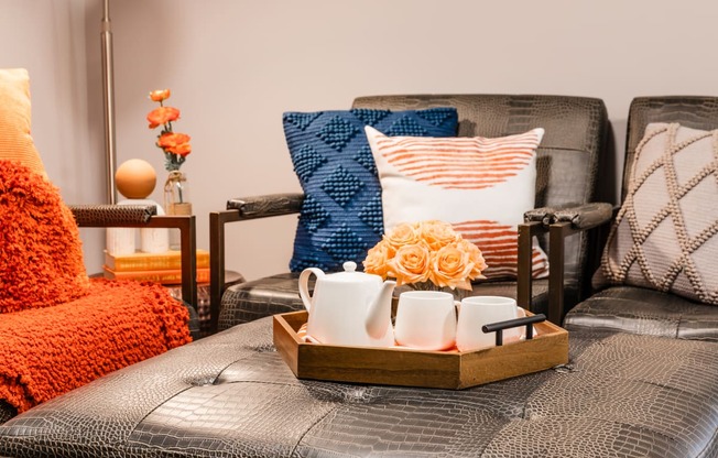 a living room with a couch and a tray with tea cups and flowers