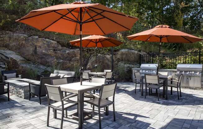 A patio with a table and chairs under umbrellas.