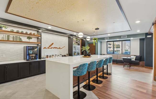 A modern kitchen with a white counter and blue chairs.
