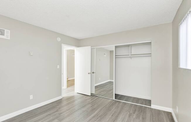 A room with a white door and a mirror on the wall.