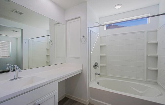 a bathroom with a tub and a sink and a mirror