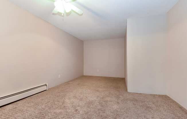 an empty room with carpet and a ceiling fan. Roseville, MN Rosedale Estates