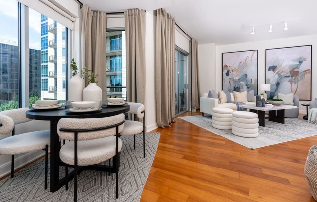 a living room with a table and chairs and a large window