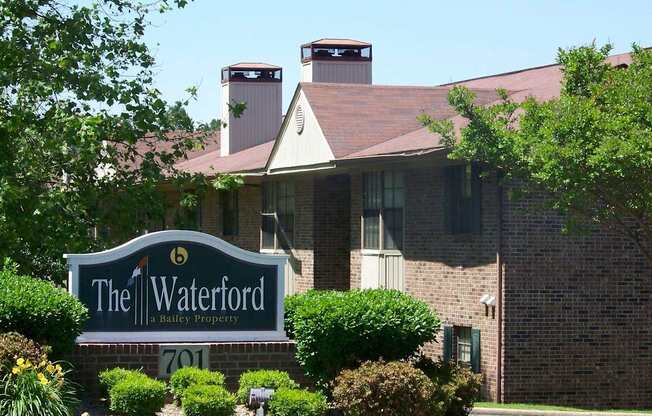 A brick building with a sign that says The Waterford in front of it.