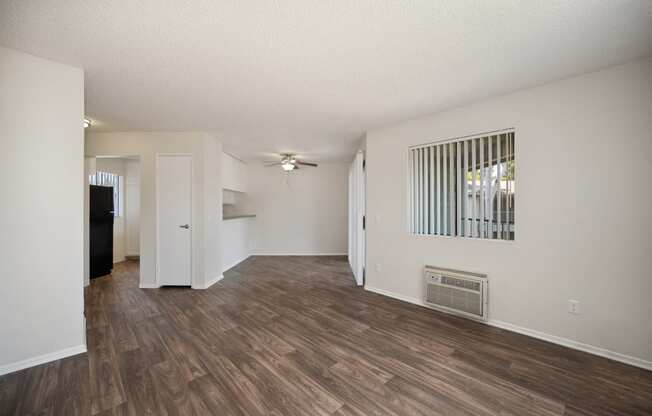 the living room and dining room of an apartment with wood flooring