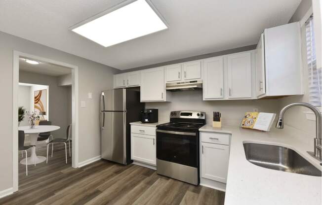 a kitchen with white cabinets and stainless steel appliances