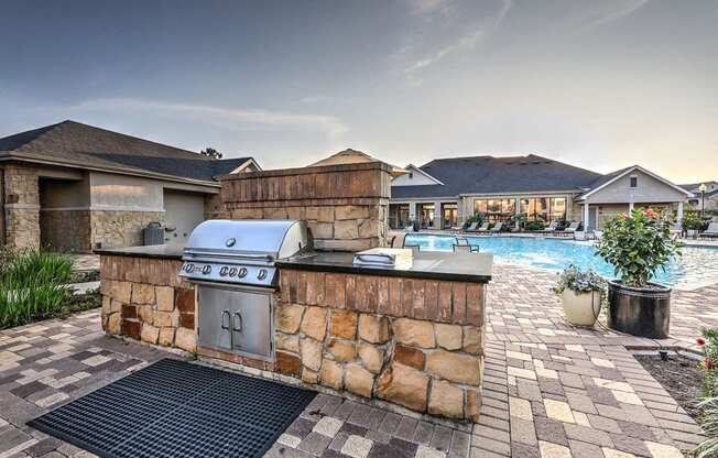 a barbecue grill in a backyard next to a swimming pool at Waterstone at Cinco Ranch, Katy, Texas