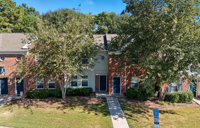 A building with a blue door and windows surrounded by trees.