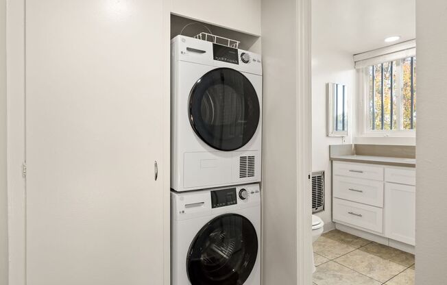 A white front loading washing machine in a laundry room.