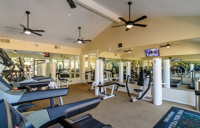 A gym with treadmills, weights, and exercise equipment.
