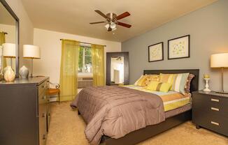 a bedroom with a bed and desk in a hotel room