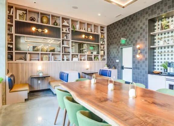 a dining room with a long wooden table and green chairs