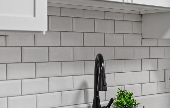 a white kitchen with a sink and white tiles