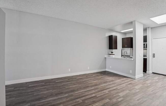A room with wooden flooring and white walls.