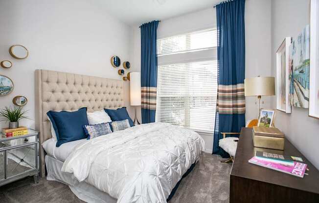 A bedroom with a large bed and a nightstand with a lamp.