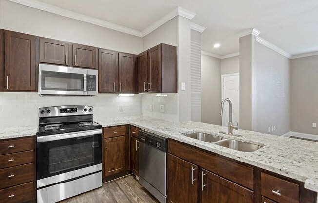 a kitchen with dark wood cabinets and white countertops at The Verandah, Texas