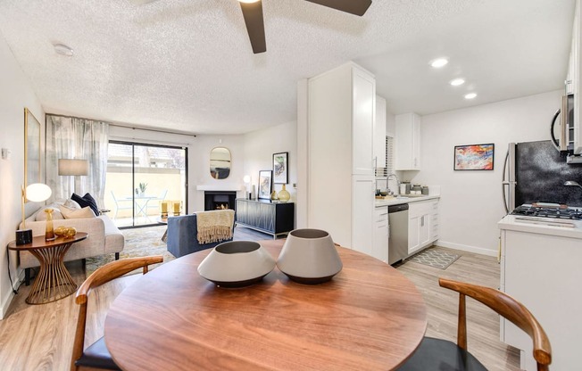 A modern kitchen with a wooden table and chairs in the foreground.